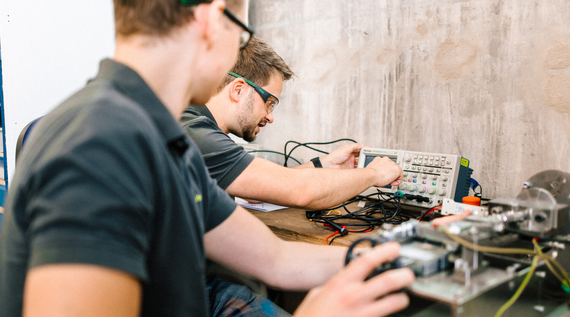 Zwei Elektrotechnikingenieure testen eine Komponente unter verschiedenen Bedingungen