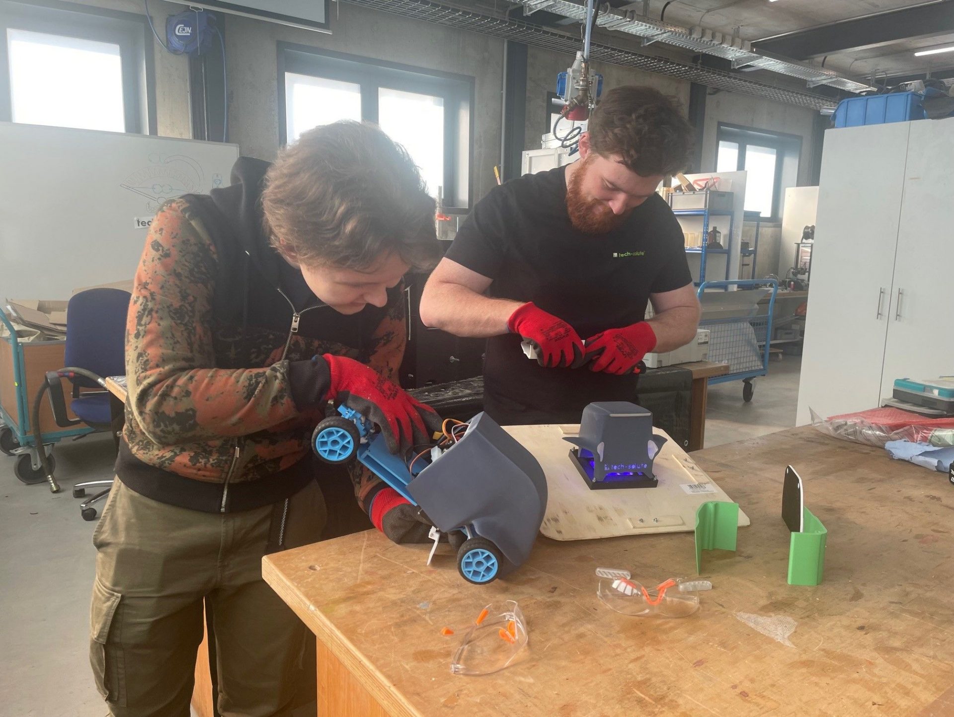 tech-solute Ingenieur mit Schüler in der Werkstatt um das Gehäuse für den New Mobility Award-Beitrag zu bauen